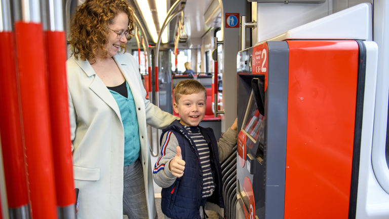 Moeder en kind kopen een kaartje Moeder en kind kopen tramkaartje bij kaartverkoopautomaat in HTM tram