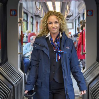 BOA controleur staan in tram HTM BOA controleur staat in HTM tram en lacht naar de camera