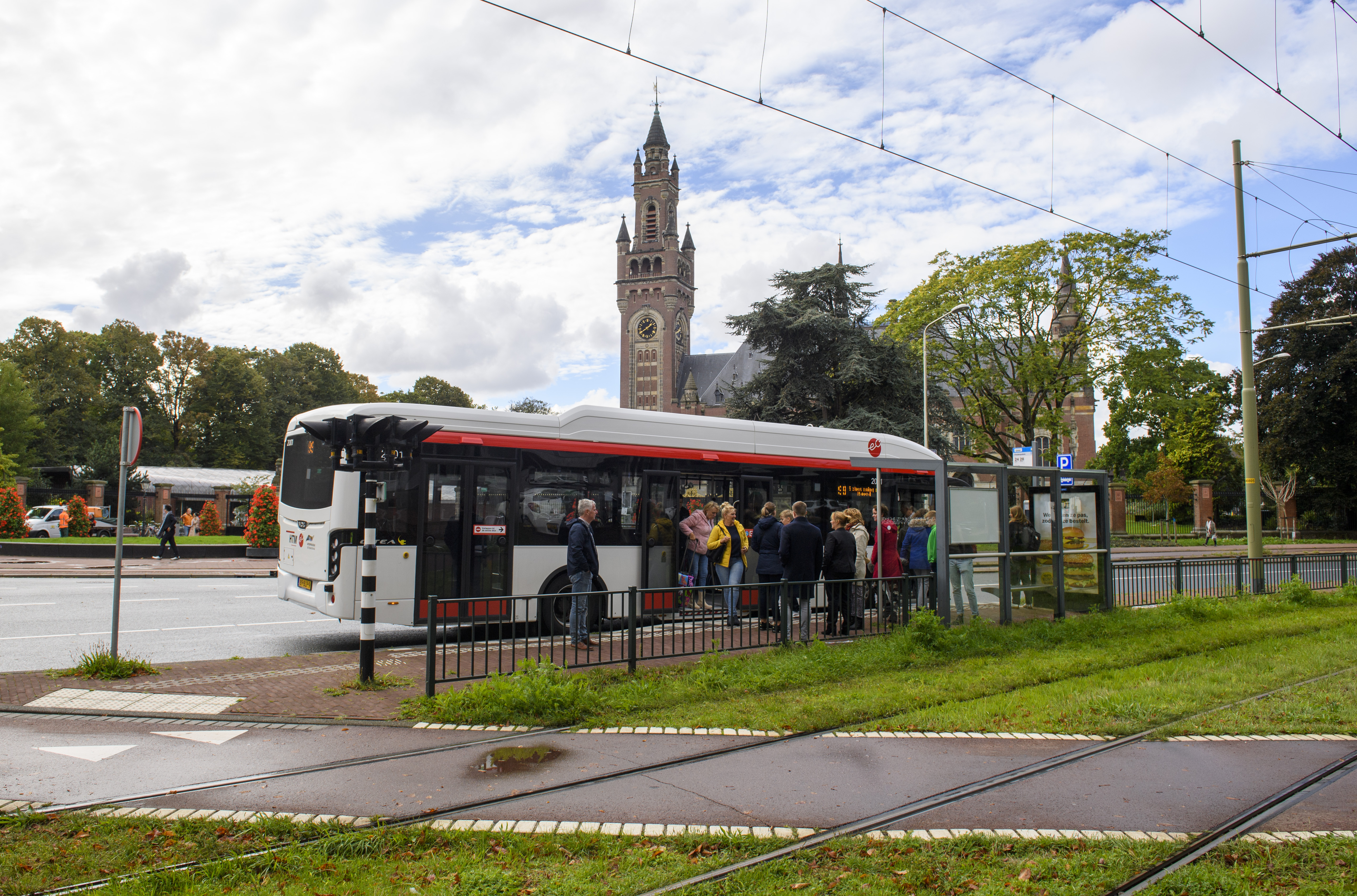 Reizigers stappen in HTM bus bij het Vredespaleis