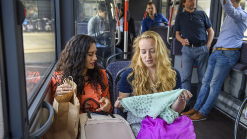 Reizigers kijken naar kleding in HTM bus Reizigers kijken naar kleding in HTM bus