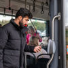 Man checkt uit met telefoon Reiziger checkt uit met OV-pay in HTM tram