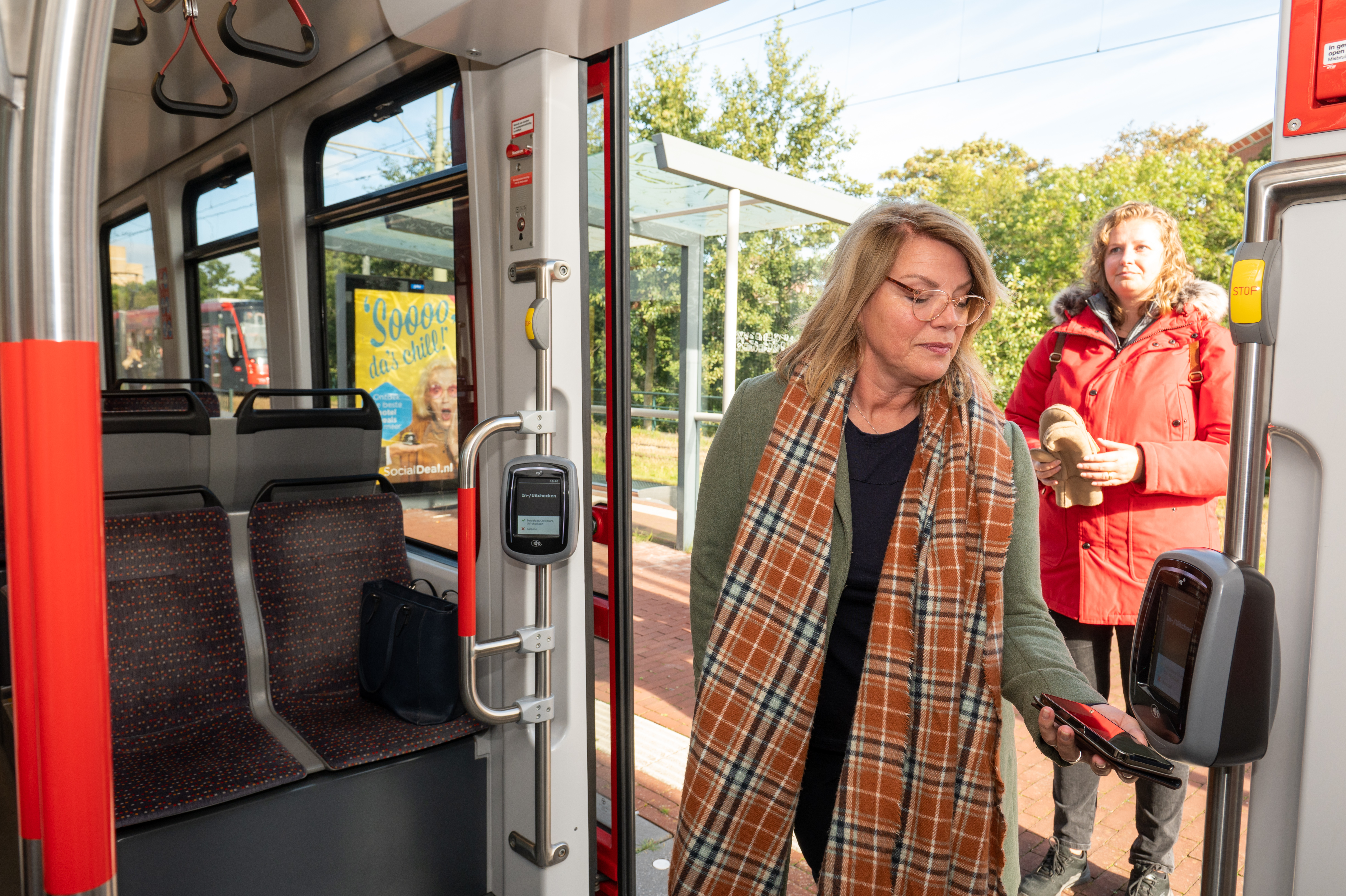 Reiziger checkt in met OV-pay in HTM tram