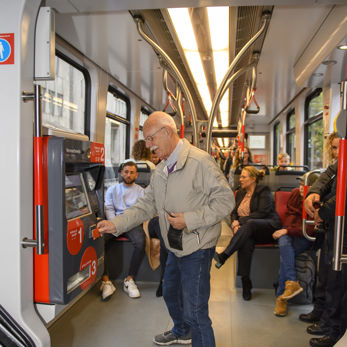 Man betaalt voor tramkaartje Reiziger betaalt met pinpas voor HTM tramkaartje in HTM tram