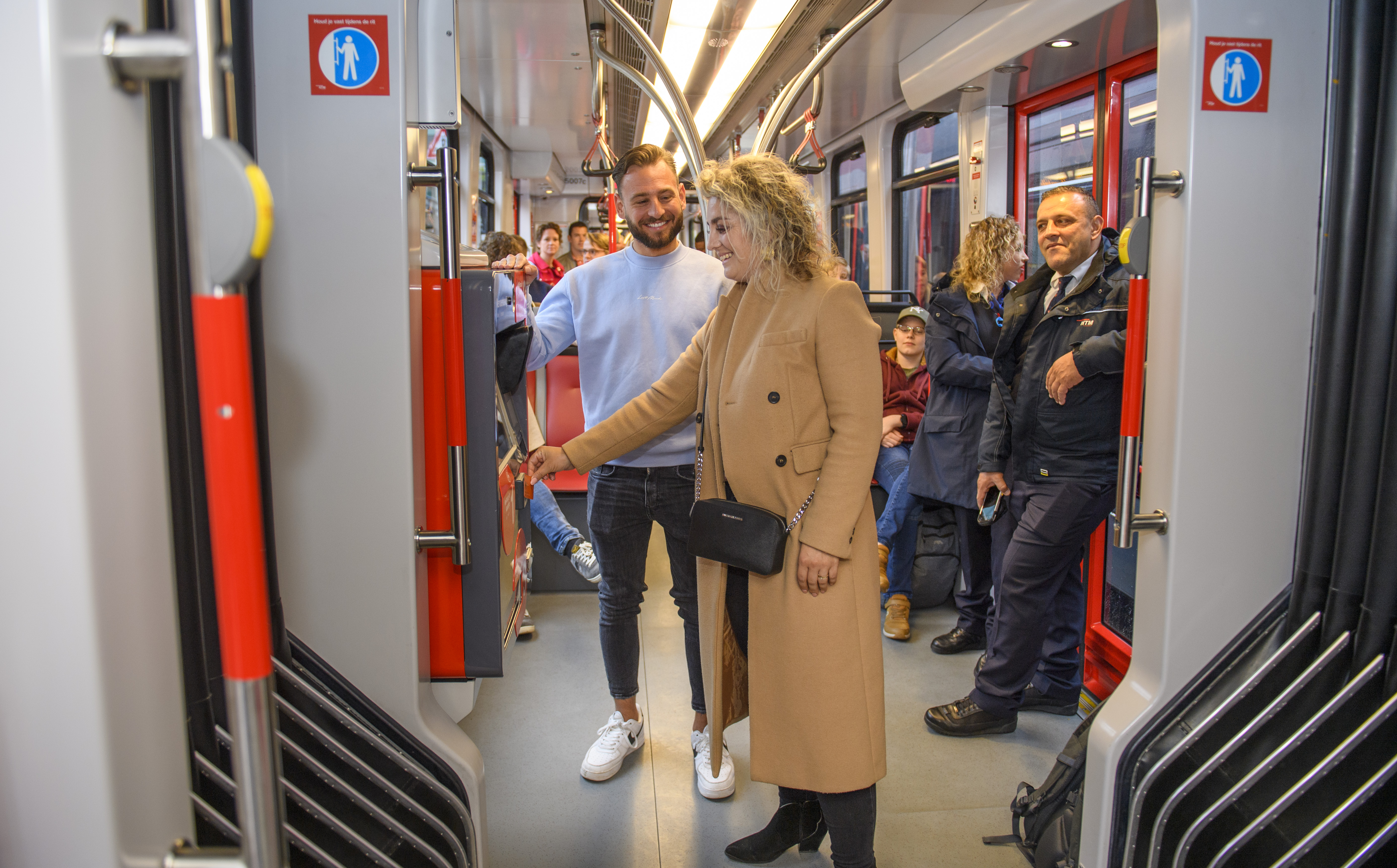 Man en vrouw kopen tramkaartje bij HTM kaartverkoopautomaat in HTM tram