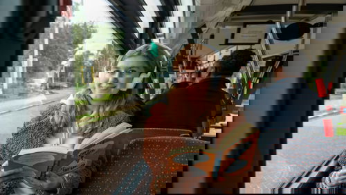 Reiziger zit in HTM bus, luistert muziek en leest een boek Reiziger zit in HTM bus, luistert muziek en leest een boek