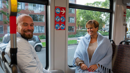 Reizigers in HTM tram Reizigers zitten in HTM tram en kijken naar de camera