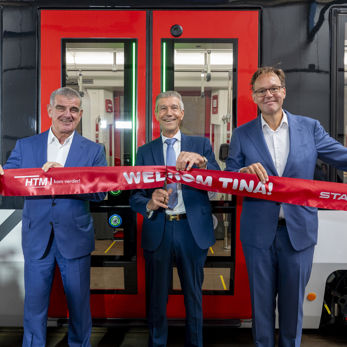Op de foto houden Peter Spuhler (voorzitter board of directors Stadler), Simon Fortuyn (regiobestuurder MRDH) en Jaap Bierman (algemeen directeur HTM) een feestelijk lint vast voor de onthulling van de TINA Op de foto houden Peter Spuhler (voorzitter board of directors Stadler), Simon Fortuyn (regiobestuurder MRDH) en Jaap Bierman (algemeen directeur HTM) een feestelijk lint vast voor de onthulling van de TINA