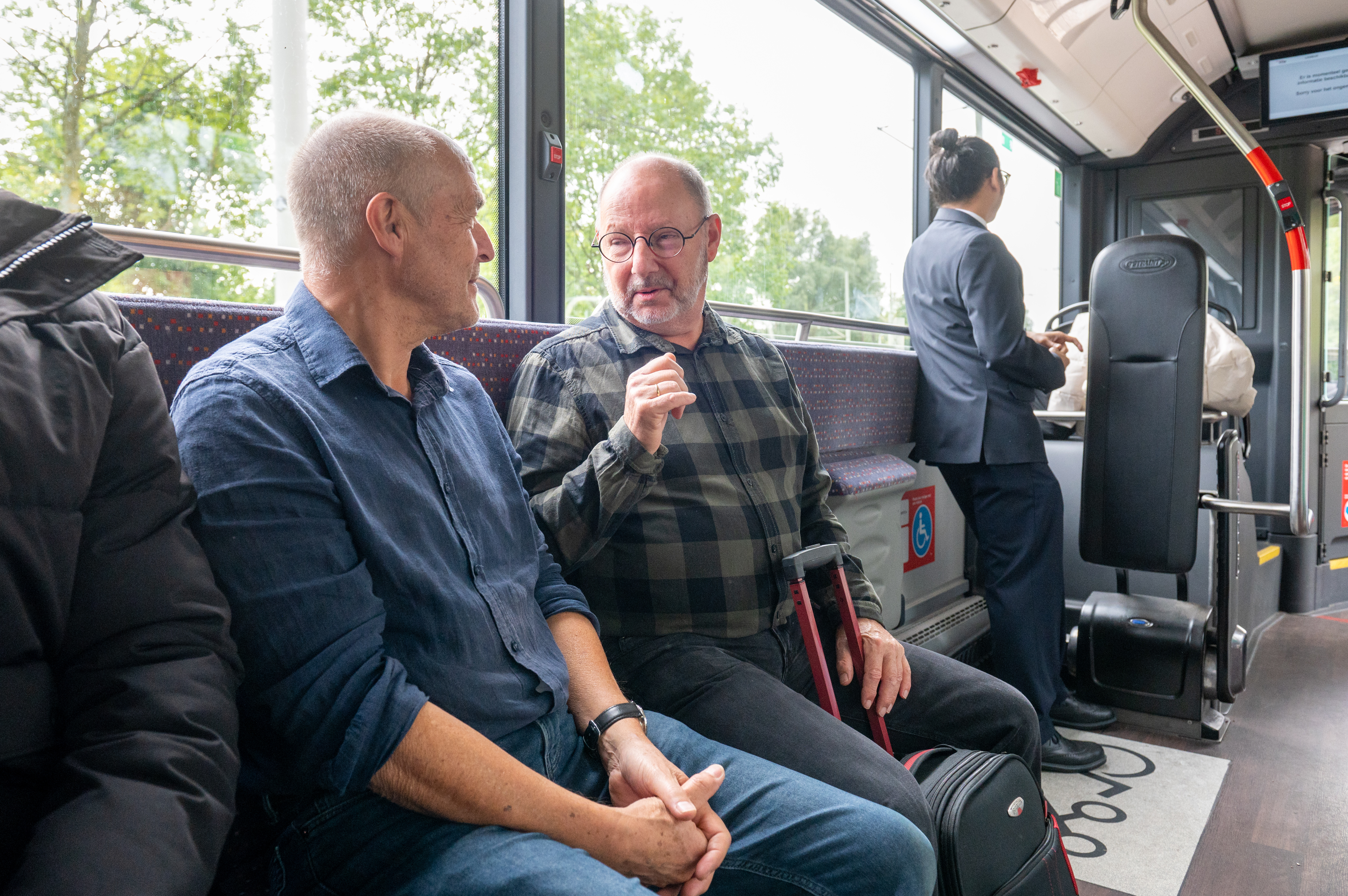Reizigers zitten in HTM bus en kijken naar elkaar